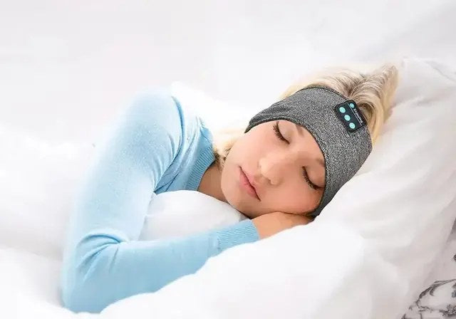 Person asleep wearing a soft grey Bluetooth sleep headband